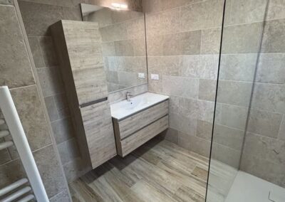 photographie prise par Zucchett'eau d'une salle de bain, douche à l'italienne d'un client, rénovée, moderne, avec un sèche-serviette.