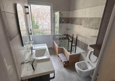 photo grand angle. Salle de bain moderne et originale avec un baignoire et un petit marchepied pour facilité l'accès